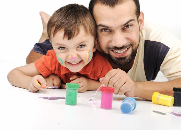 father and son doing face painting